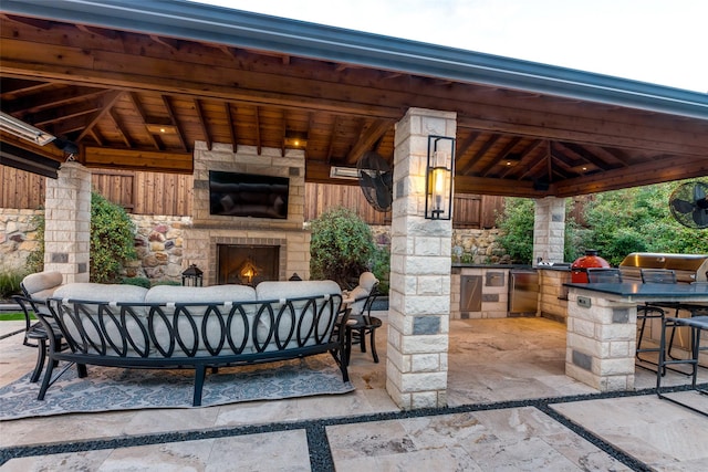 view of patio with a gazebo, an outdoor kitchen, a grill, and an outdoor living space with a fireplace