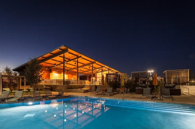 view of pool at twilight