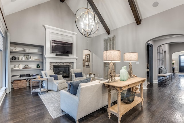 living room with an inviting chandelier, a high end fireplace, dark hardwood / wood-style floors, and high vaulted ceiling