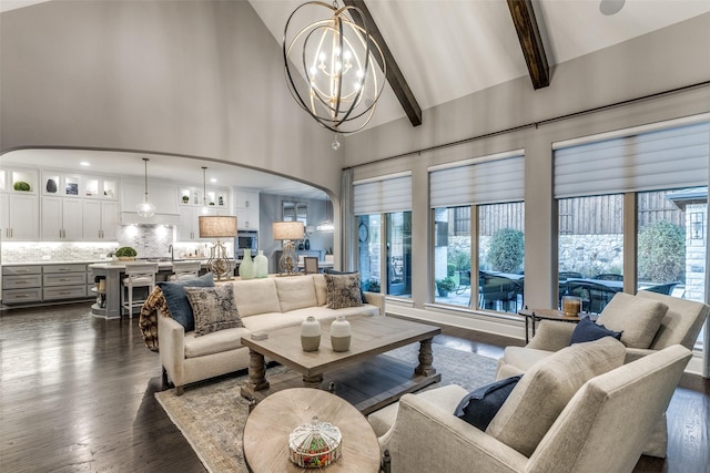 living room with an inviting chandelier, beam ceiling, dark wood-type flooring, and high vaulted ceiling