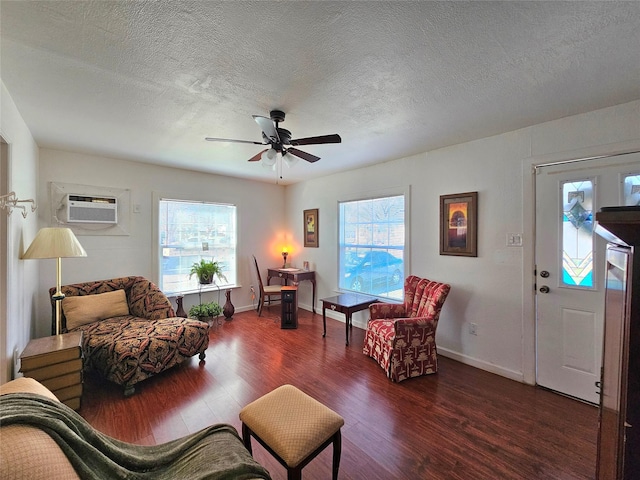 living room featuring a textured ceiling, a wealth of natural light, dark wood-type flooring, and a wall mounted air conditioner