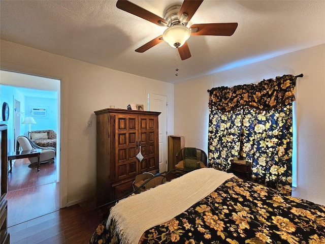 bedroom featuring ceiling fan, dark hardwood / wood-style flooring, and a textured ceiling