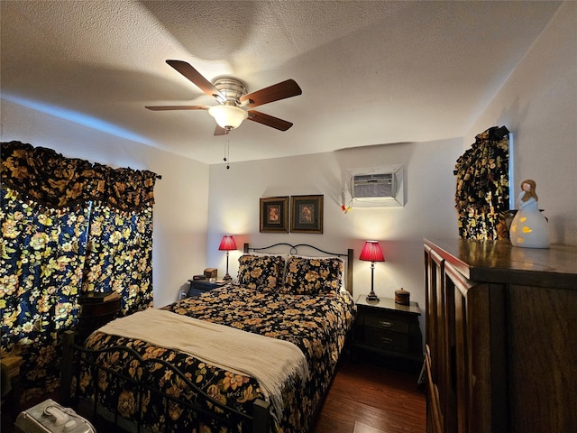 bedroom with an AC wall unit, ceiling fan, dark hardwood / wood-style flooring, and a textured ceiling