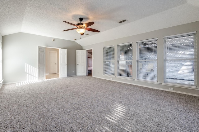 empty room with ceiling fan, carpet floors, and vaulted ceiling