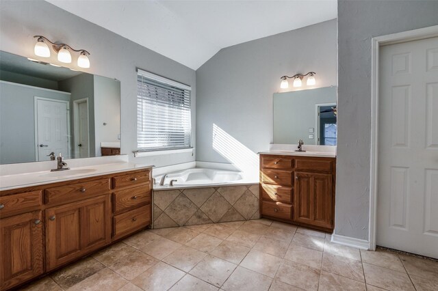 bathroom featuring tile patterned floors, tiled bath, vanity, and vaulted ceiling