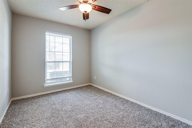 carpeted empty room with ceiling fan and a textured ceiling