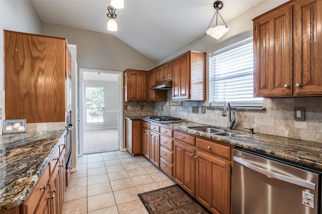 kitchen with a textured ceiling, stainless steel appliances, plenty of natural light, and hanging light fixtures