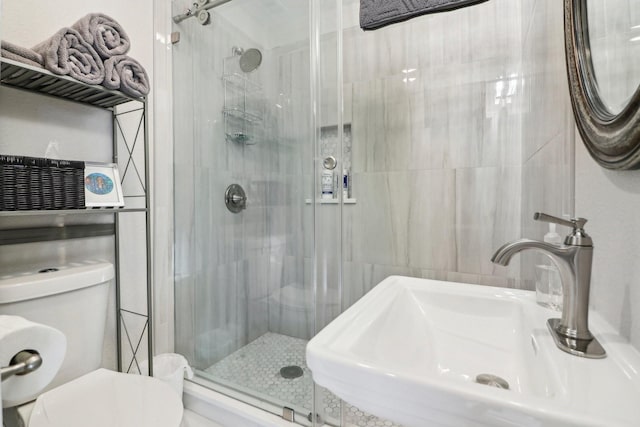 bathroom featuring sink, toilet, and a shower with door