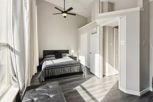 bedroom with ceiling fan, high vaulted ceiling, and dark hardwood / wood-style flooring