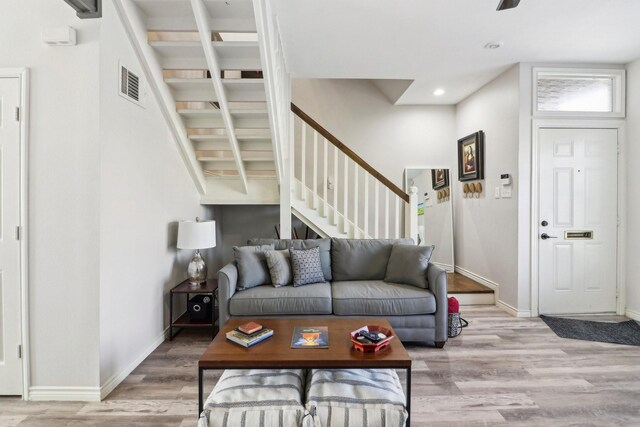 living room featuring hardwood / wood-style flooring, beam ceiling, and ceiling fan