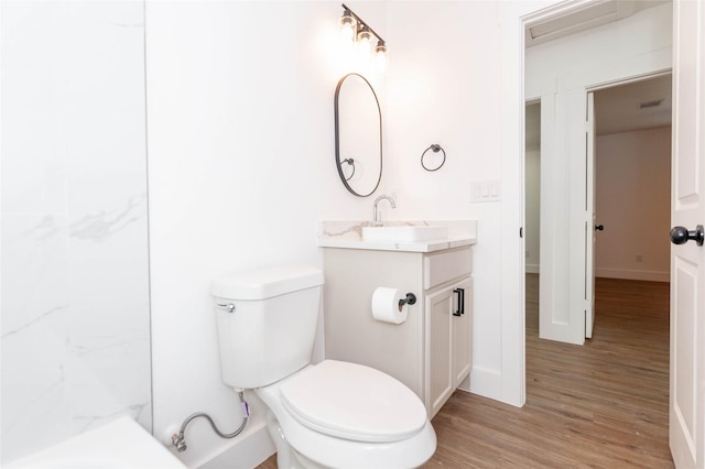 bathroom with wood-type flooring, vanity, and toilet