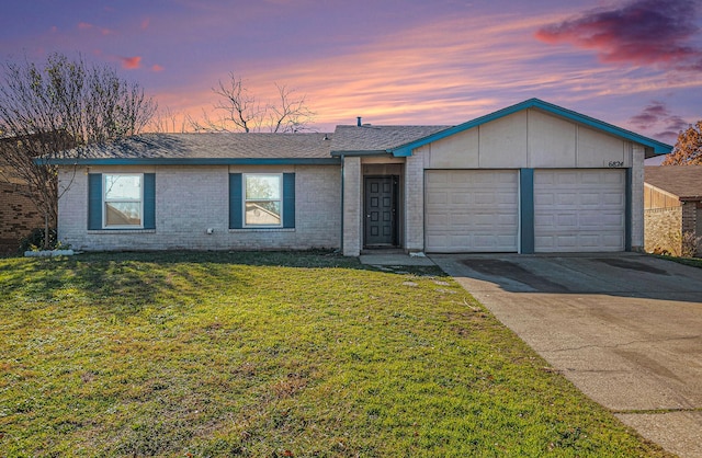 single story home featuring a garage and a lawn