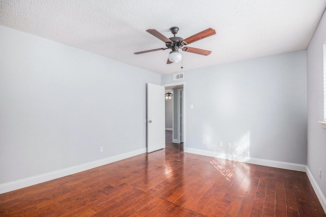 spare room with visible vents, a ceiling fan, a textured ceiling, baseboards, and hardwood / wood-style flooring