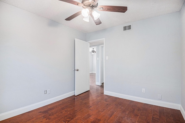 empty room featuring wood-type flooring, visible vents, and baseboards