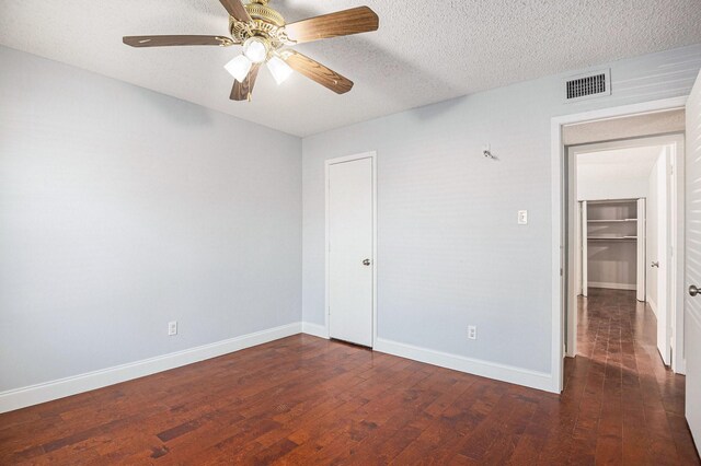 spare room featuring ceiling fan, dark hardwood / wood-style flooring, and a textured ceiling