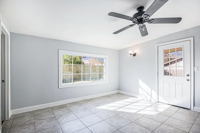 spare room with light tile patterned flooring, ceiling fan, and baseboards