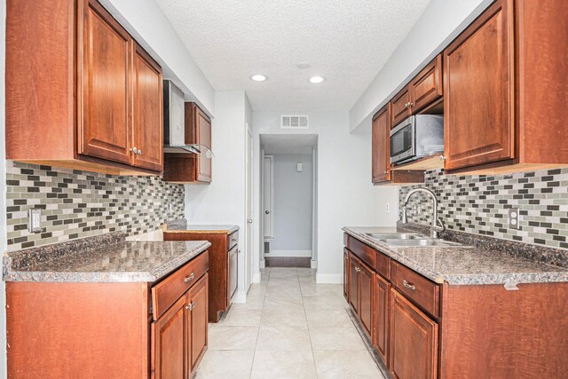 kitchen featuring backsplash, sink, ceiling fan, wall chimney exhaust hood, and a textured ceiling