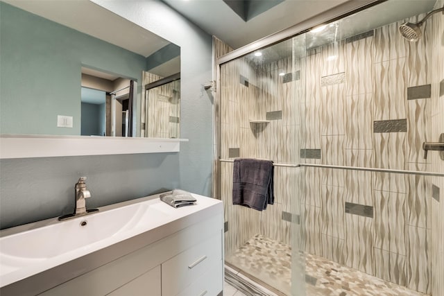 bathroom featuring walk in shower and vanity