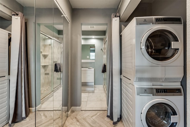 laundry area featuring stacked washer / drying machine