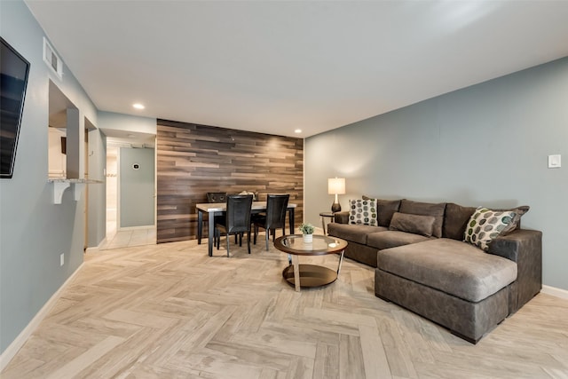 living room with light parquet flooring and wood walls