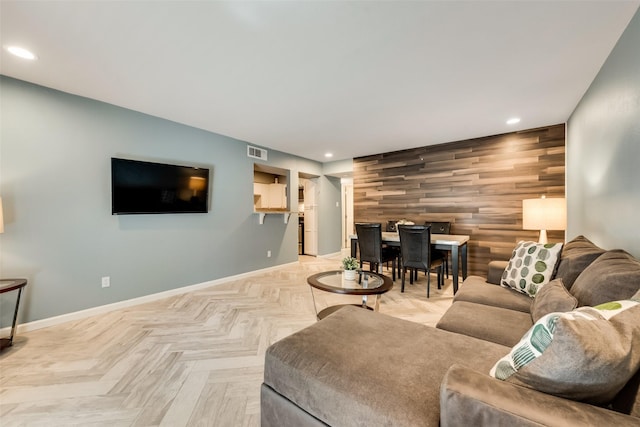 living room featuring light parquet flooring and wood walls