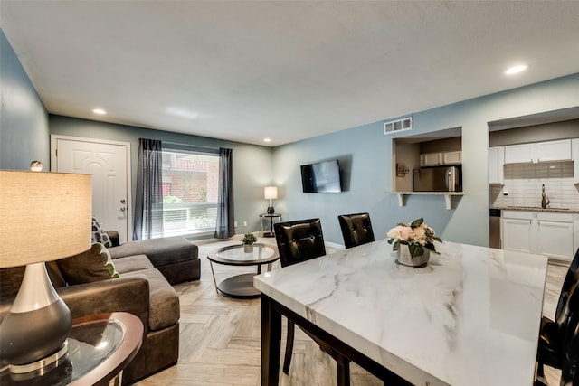 dining area with light parquet floors and sink