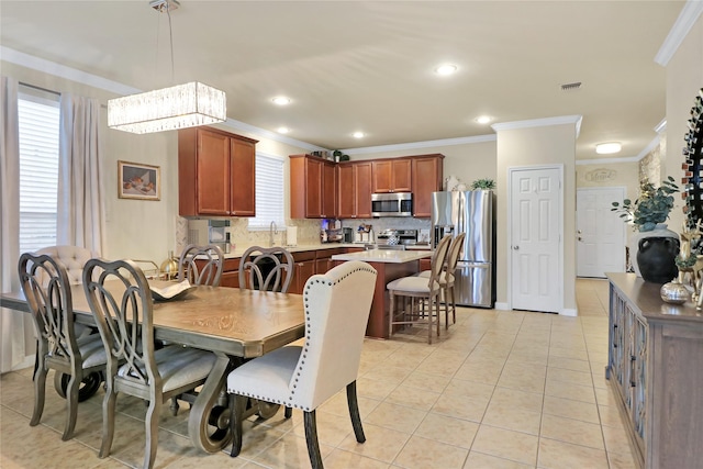 dining room featuring plenty of natural light, light tile patterned flooring, ornamental molding, and a chandelier