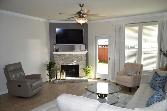 living room featuring a stone fireplace, ceiling fan, tile patterned flooring, and crown molding