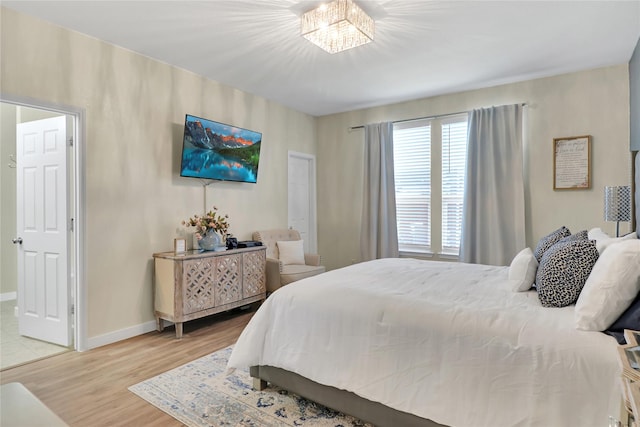 bedroom with wood-type flooring and an inviting chandelier