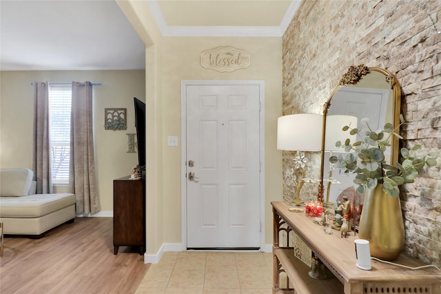 entryway with crown molding and light hardwood / wood-style floors