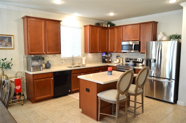 kitchen with a center island, sink, ornamental molding, a kitchen bar, and stainless steel appliances