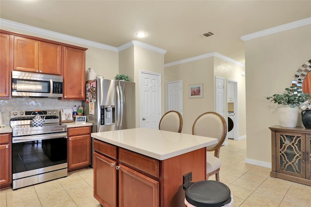 kitchen featuring light tile patterned floors, a center island, stainless steel appliances, and crown molding