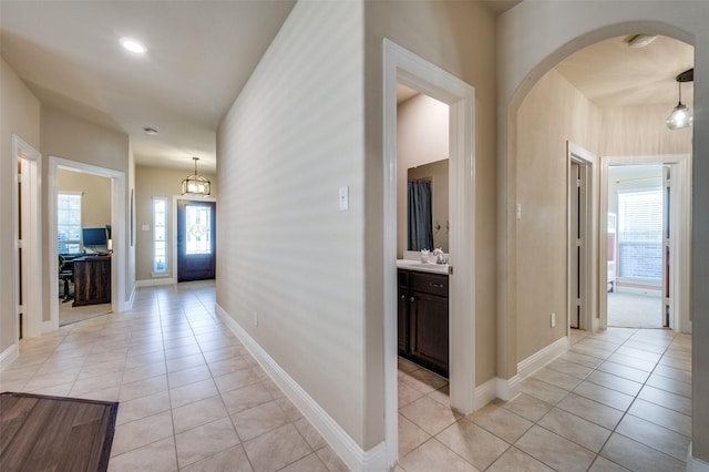 hallway featuring light tile patterned floors and sink