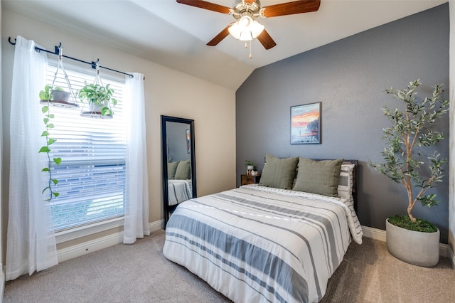 carpeted bedroom with ceiling fan and vaulted ceiling