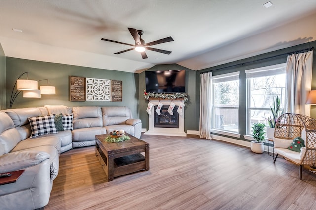 living room with ceiling fan, hardwood / wood-style floors, and vaulted ceiling