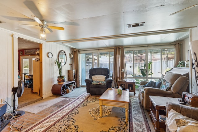 living room featuring ceiling fan, a wealth of natural light, and french doors