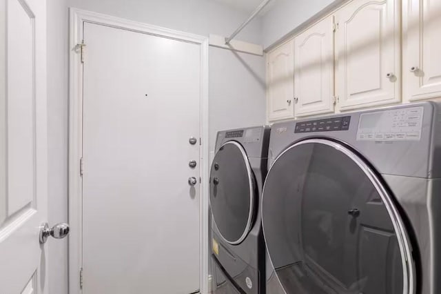 laundry area featuring washer and clothes dryer and cabinets