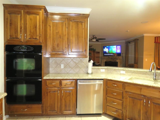 kitchen featuring sink, decorative backsplash, black double oven, stainless steel dishwasher, and light stone counters