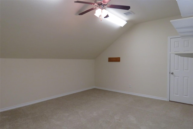 bonus room with light colored carpet, baseboards, visible vents, a ceiling fan, and lofted ceiling