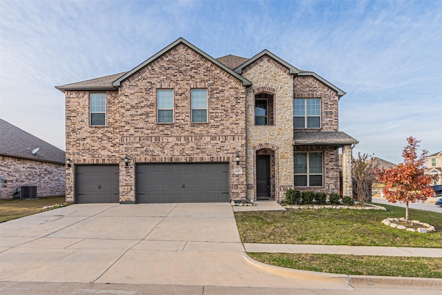 view of front of house with a front lawn, a garage, and central AC