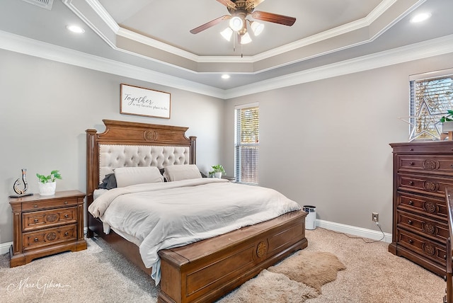 bedroom with multiple windows, a tray ceiling, and light colored carpet