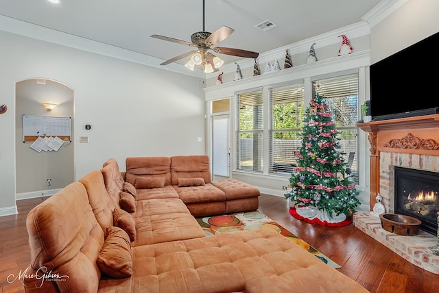 living room featuring ornamental molding, a brick fireplace, hardwood / wood-style floors, and ceiling fan