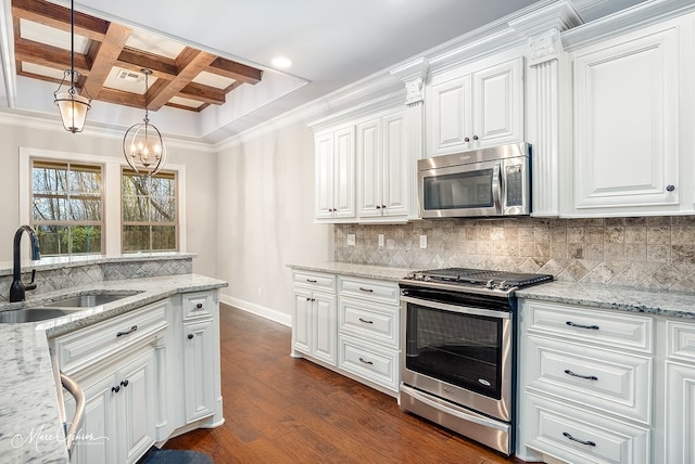 kitchen featuring white cabinets, stainless steel appliances, hanging light fixtures, and dark wood-type flooring