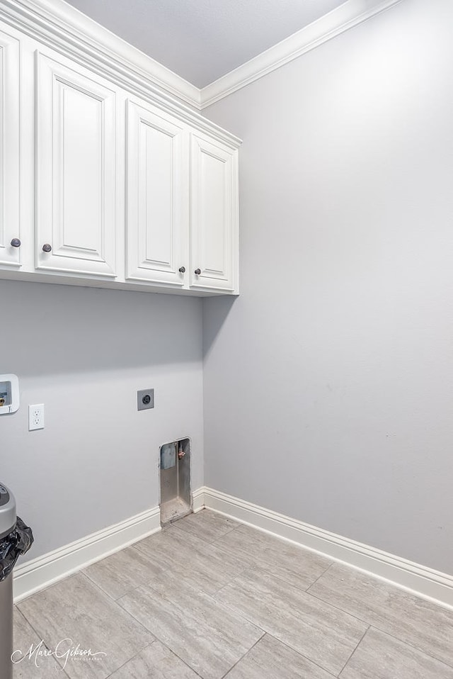 clothes washing area with hookup for an electric dryer, hookup for a washing machine, cabinets, crown molding, and light hardwood / wood-style floors