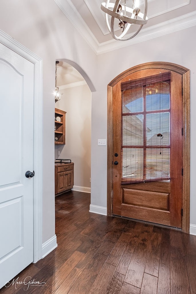 entrance foyer with a notable chandelier, dark hardwood / wood-style floors, and ornamental molding