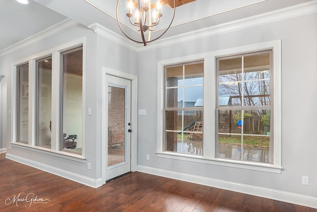 doorway to outside with dark hardwood / wood-style flooring, crown molding, and a notable chandelier