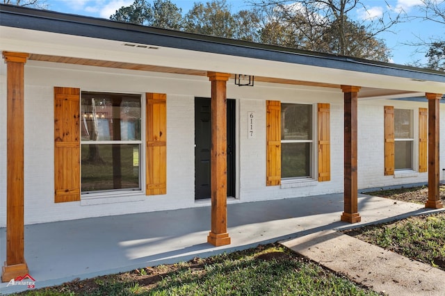 view of exterior entry featuring covered porch