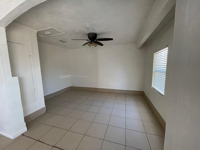 spare room featuring light tile patterned floors, ceiling fan, and ornamental molding