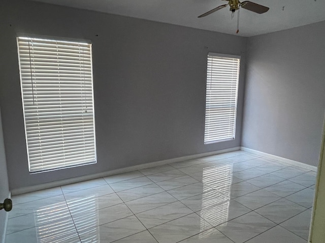 tiled spare room with ceiling fan