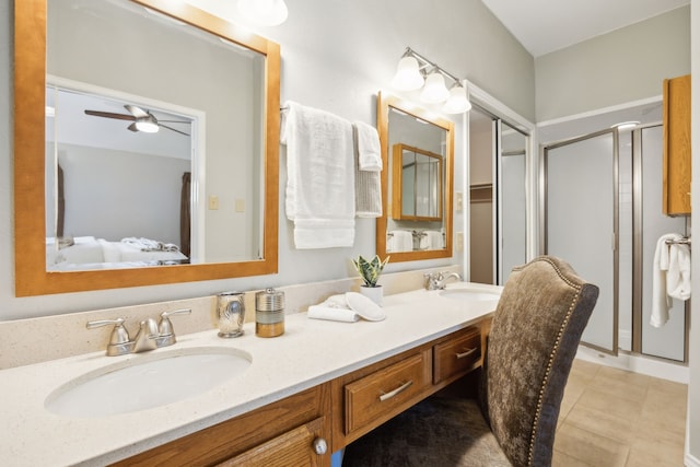 bathroom with tile patterned floors, ceiling fan, a shower with door, and vanity